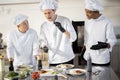 Cooks with different nationalties tasting cooked meals for restaurant menu Royalty Free Stock Photo