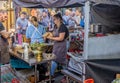 Cooks preparing and serving food from a stall at the Great Bath Feast street food festival in Milsom Street, Bath, Avon, UK