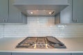 Cooktop with burners fixed on the kitchen countertop of home with exhaust hood