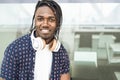 Cool African American man portrait in the city with music headphones and smiling, positive attitude Royalty Free Stock Photo