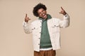 Cool African American teen guy showing rock n roll hand sign isolated on beige. Royalty Free Stock Photo