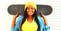 Cool african woman with skateboard in colorful clothes Royalty Free Stock Photo