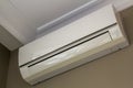 Cool air conditioner installed in room interior on white ceiling and light walls copy space background. Climate control, Royalty Free Stock Photo