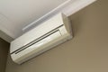 Cool air conditioner installed in room interior on white ceiling and light walls copy space background. Climate control,
