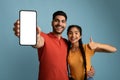 Cool App. Happy Arab Couple Demonstrating Blank Smartphone And Showing Thumb Up