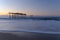 Cool Atlantic ocean waves wash up near a dilapidated pier