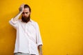 Cool bearded hipster on yellow wall