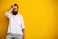 Cool bearded hipster on yellow wall