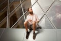 Cool bearded tattooed guy posing in front of office building Royalty Free Stock Photo