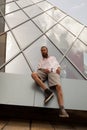 Cool bearded tattooed hipster posing in front of office building Royalty Free Stock Photo