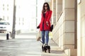 Cool beautiful young woman walking while shopping for the city with her little dog