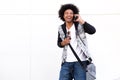 Cool black guy laughing with mobile phone and bag Royalty Free Stock Photo