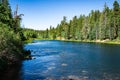 Cool Blue mountain lake ready for fishing, swimming and wading with crystal clear water surrounded by forest Royalty Free Stock Photo