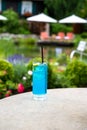 Cool, blue summer drink by the lake. Cooling blue refreshing drink with fresh lime slice and ice cubes. Royalty Free Stock Photo