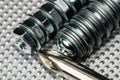 Cool blue toned macro of small bolts with nuts and washers on an industrial steel surface with the top of a phillips head Royalty Free Stock Photo