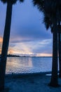 Cool blues in this tropical paradise water scene. Silhouette of palm trees over the water.. Royalty Free Stock Photo