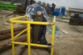 Cool boy in a coat and hat with a scarf posing plays and walks through pipes with an umbrella in an industrial area Royalty Free Stock Photo