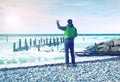 Cool boy makes photo of calm sea. Man takes picture Royalty Free Stock Photo