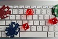 Cool casino chips and dice on laptop computer keyboard Royalty Free Stock Photo