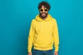 Cool casual man in yellow hoodie wearing sunglasses and smiling Royalty Free Stock Photo