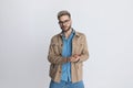 Cool casual young man in denim shirt with glasses rubbing palms