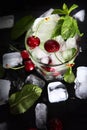 Cool cherry lemonade in a glass with ice and mint. Mint leaves in a glass. Seasonal summer drink. Photo on a black background Royalty Free Stock Photo