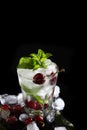 Cool cherry lemonade in a glass with ice and mint. Mint leaves in a glass. Seasonal summer drink. Photo on a black background. Royalty Free Stock Photo