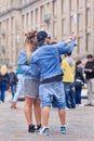 Cool dressed couple takes selfie on Dam Square, Amsterdam, Netherlands