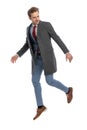 Cool dynamic young man in suit with jacket looking to side and jumping up Royalty Free Stock Photo