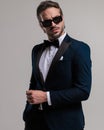 cool elegant businessman in tuxedo with sunglasses holding hand in pocket Royalty Free Stock Photo