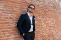 cool elegant man with sunglasses holding hands in pockets and posing Royalty Free Stock Photo