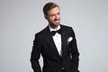 Cool elegant man in tuxedo is laughing while looking away