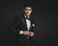 cool elegant young man buttoning his tuxedo coat Royalty Free Stock Photo