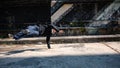 A cool, energetic Asian male hiphop dancer is practicing his b-boy breakdance on the street