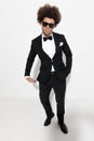 cool fashion groom with big curly hair holding hand in pockets Royalty Free Stock Photo