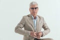 Cool fashion man in his 60s with sunglasses buttoning suit Royalty Free Stock Photo