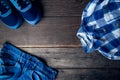 Cool fashion men`s casual outfit on wooden table, trendy in summer, t-shirt, blue jeans pants, sneaker, top view. Royalty Free Stock Photo