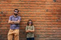 Cool father and son leaning against a brick wall outside