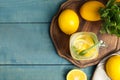 Cool freshly made lemonade and fruits on light blue wooden table, flat lay. Space for text