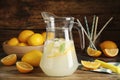 Cool freshly made lemonade in glass pitcher and fresh fruits on wooden table Royalty Free Stock Photo