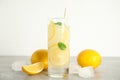 Cool freshly made lemonade, ice cubes and fruits on grey table Royalty Free Stock Photo