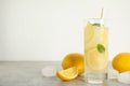 Cool freshly made lemonade, ice cubes and fruits on grey table. Space for text Royalty Free Stock Photo