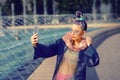 Cool funky hipster young fashion influencer girl with crazy hair and avant garde style taking selfie on street Royalty Free Stock Photo