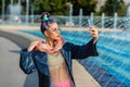 Cool funky young woman with fashion outfit taking selfie outdoor