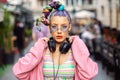 Cool funky young woman with trendy eyeglasses listening music on headphones outdoor Royalty Free Stock Photo