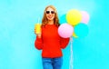 Cool funny girl with an air balloons holds cup of fruit juice