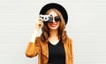 Cool funny girl model with retro film camera wearing a elegant hat, brown jacket Royalty Free Stock Photo