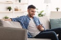 Closeup of smiling jewish man using smartphone at home