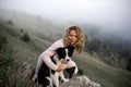 Cool Girl and dog border collie on edge of rock in fog smiling Royalty Free Stock Photo