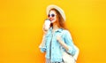 Cool girl drinks a coffee on orange background